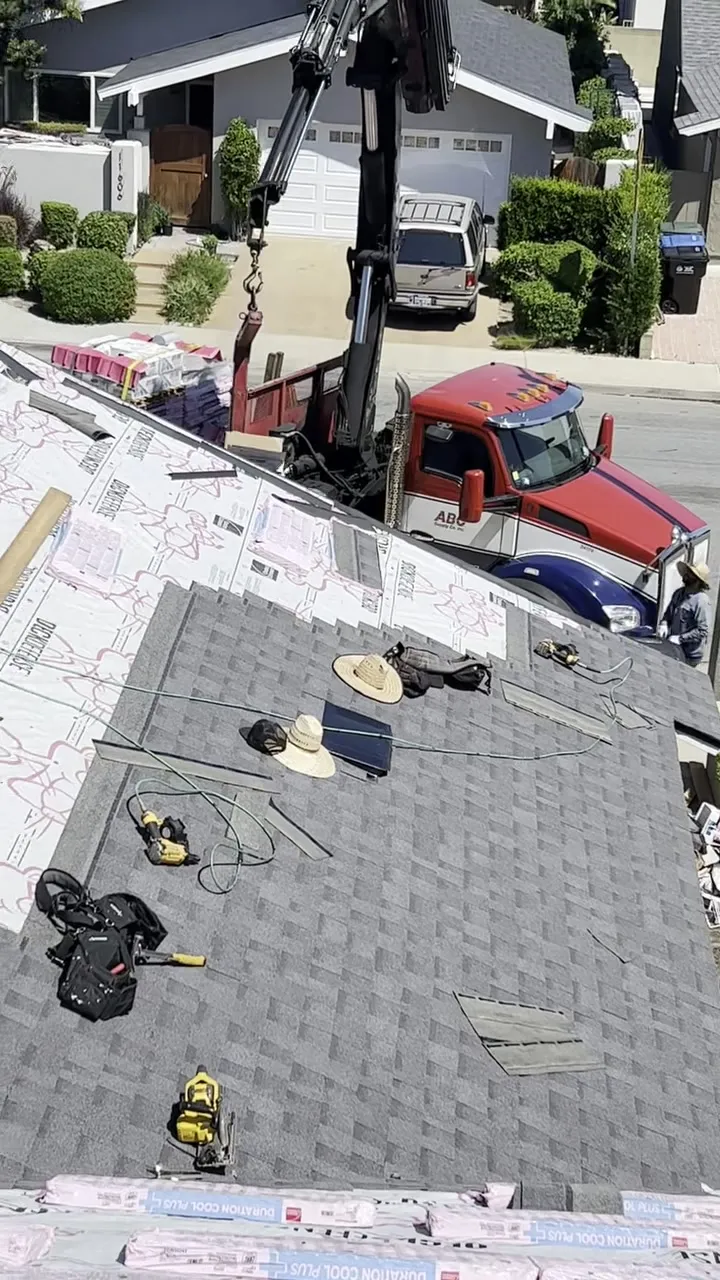Cuadrilla de Pacific Roofing instalando un techo de shingle nuevo, material y herramienta en el techo